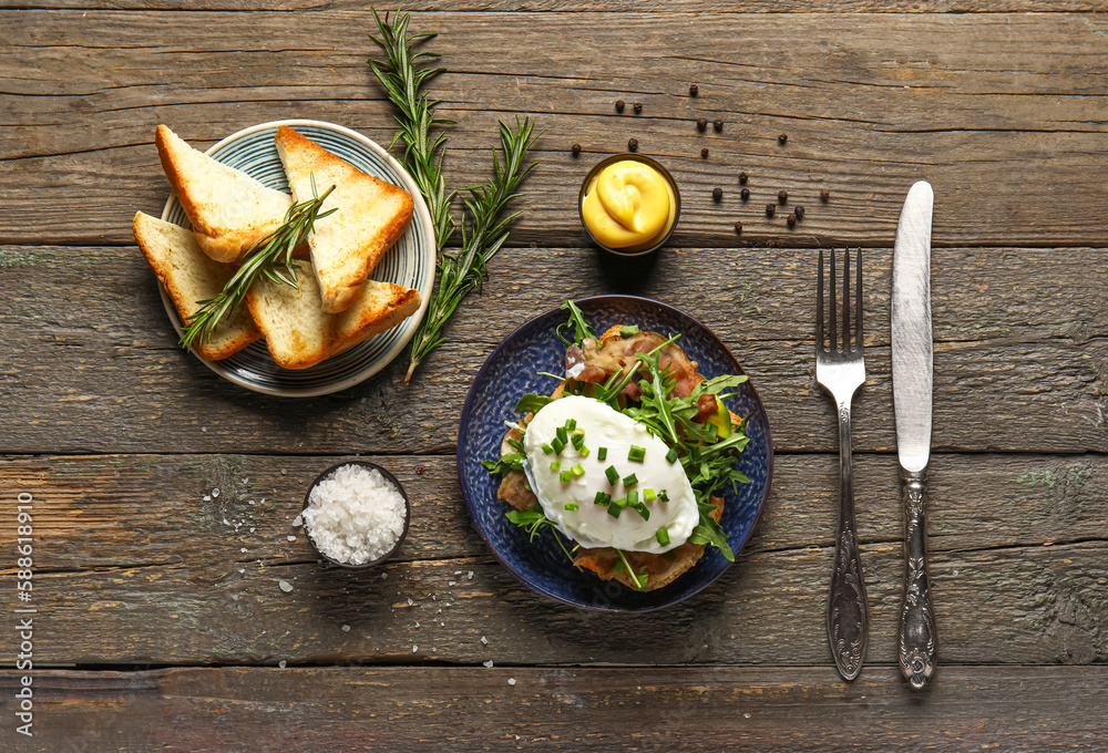 Plate with tasty egg Benedict on wooden background