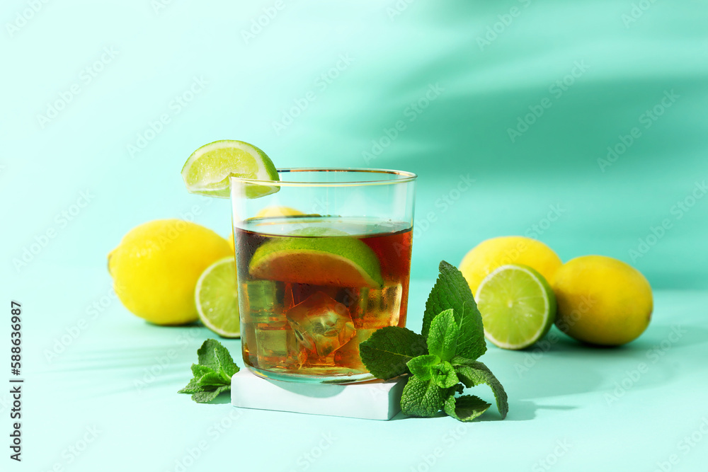 Glass of cold rum on turquoise background