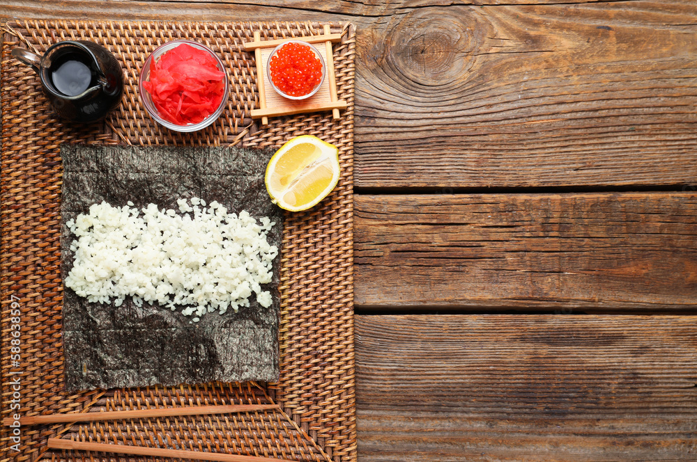 Nori with rice, ginger and sauce on wooden background