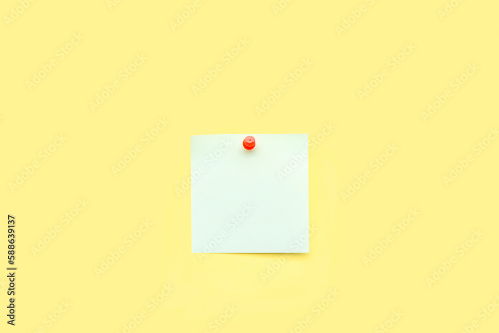 Pinned sticky note and pin on yellow background