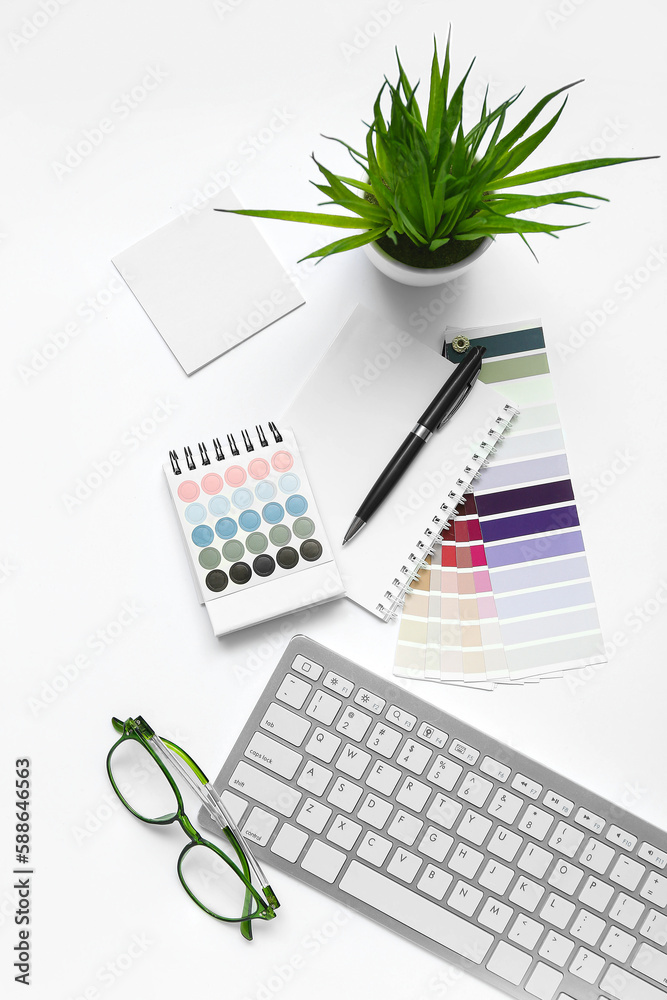 Composition with eyeglasses, keyboard and notepad on white background