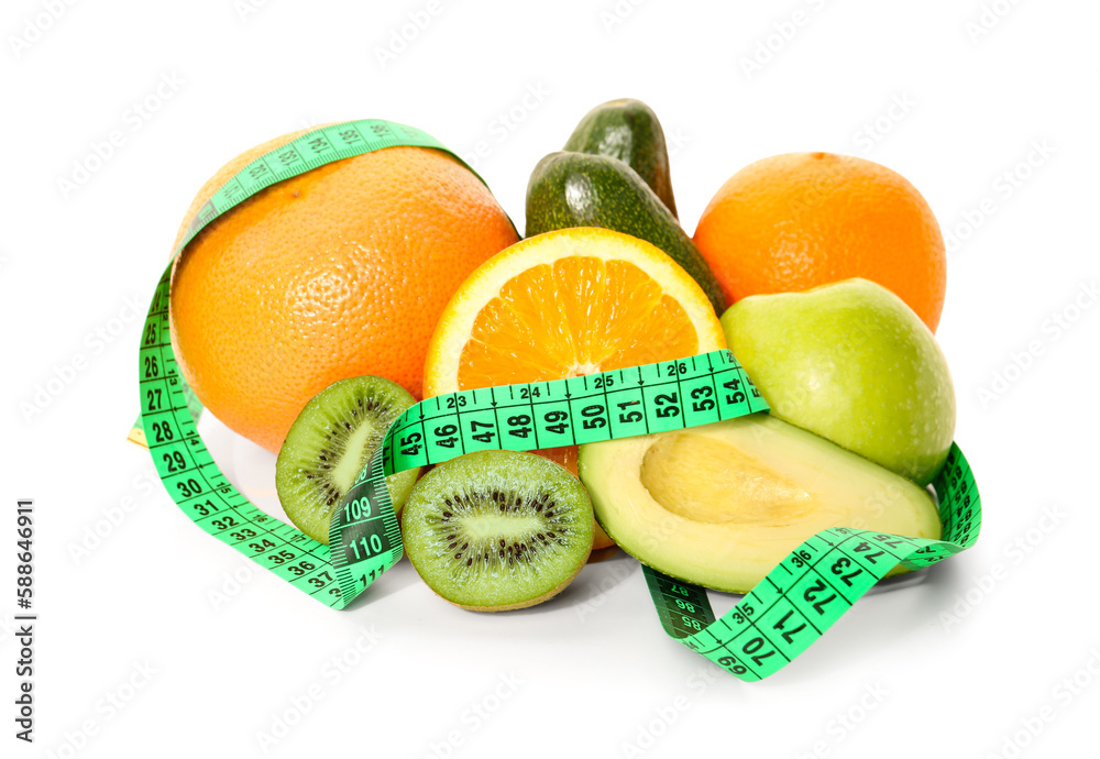 Different fruits, avocado and green measuring tape on white background. Diet concept