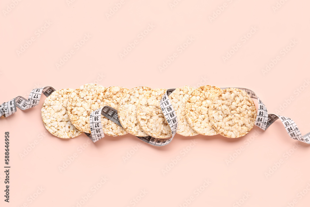 Rice cakes and measuring tape on pink background. Diet concept