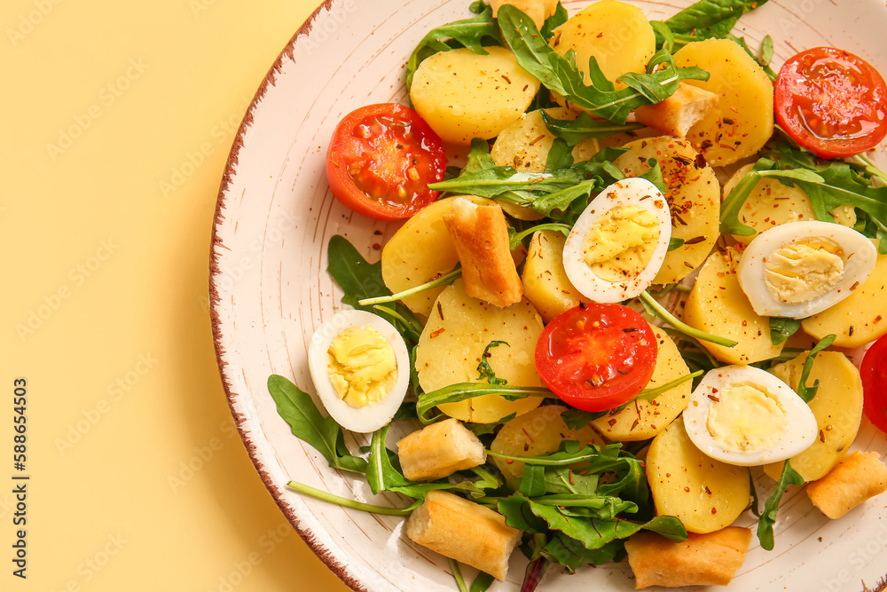 Plate of tasty potato salad with eggs and tomatoes on beige background, closeup