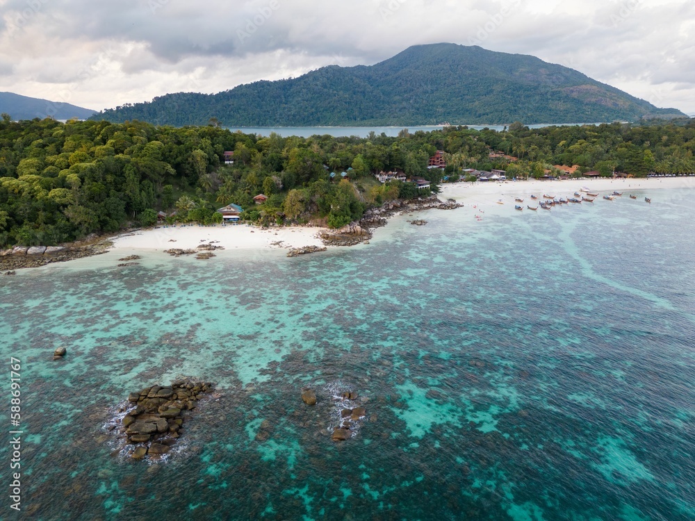 Aerial shot of Sanom Beach with green trees on Ko Lipe island in Thailand surrounded by the blue sea