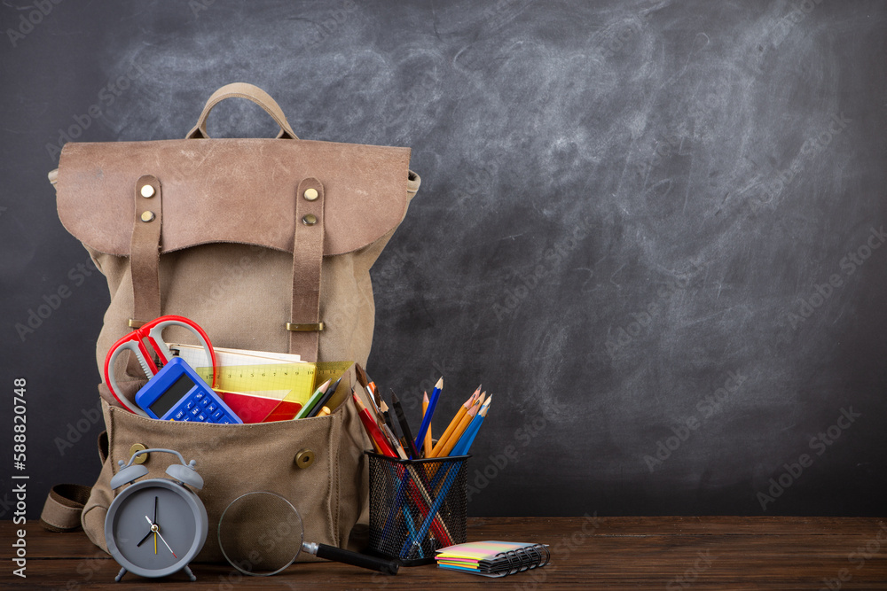 Back to school - books and school backpack on the desk in the auditorium, Education concept.