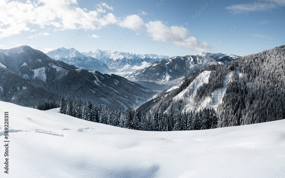 Panoramic view of winter wonderland mountain scenery with the alpine town of Zell am See and Zeller 