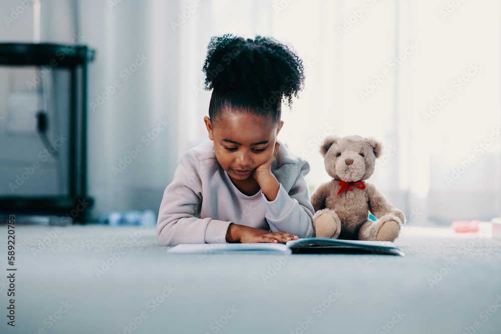 Elementary age child reading a book in her bedroom