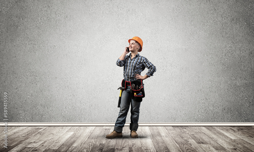 Attractive woman in workwear and hardhat