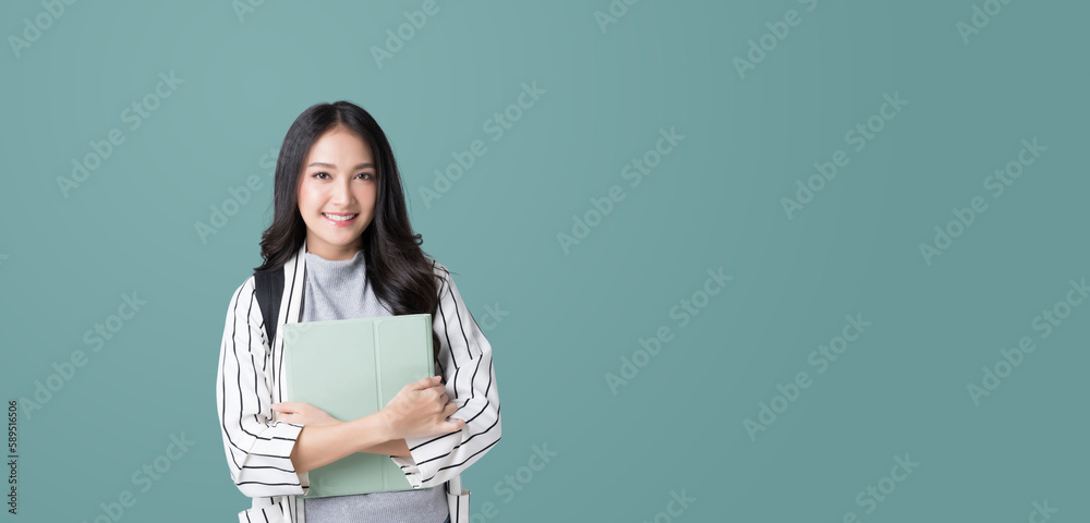 Young Asian girl college student with tablet and backpack isolated over teal background