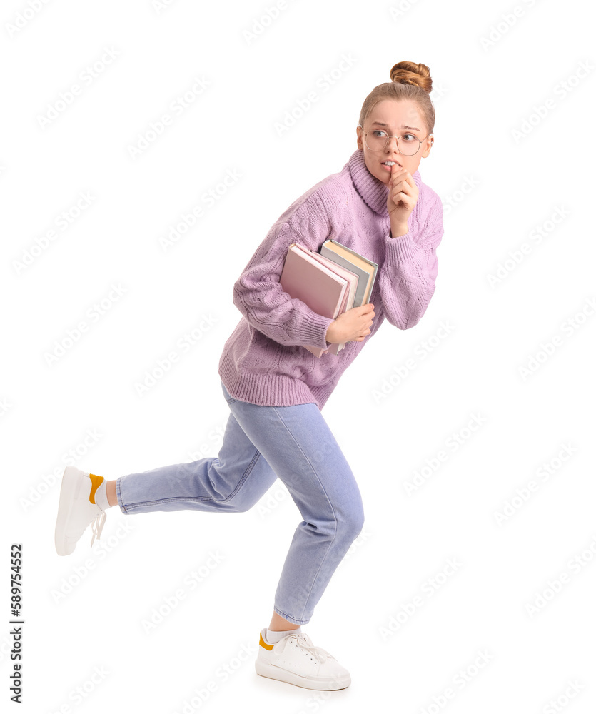 Young woman with books biting nails on white background