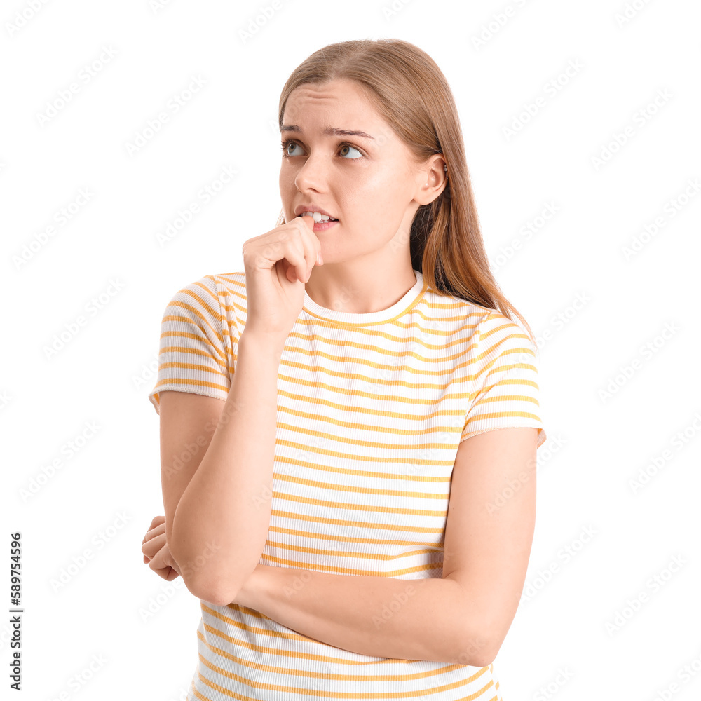 Young woman biting nails on white background