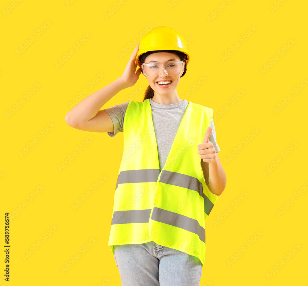 Female worker in vest on yellow background