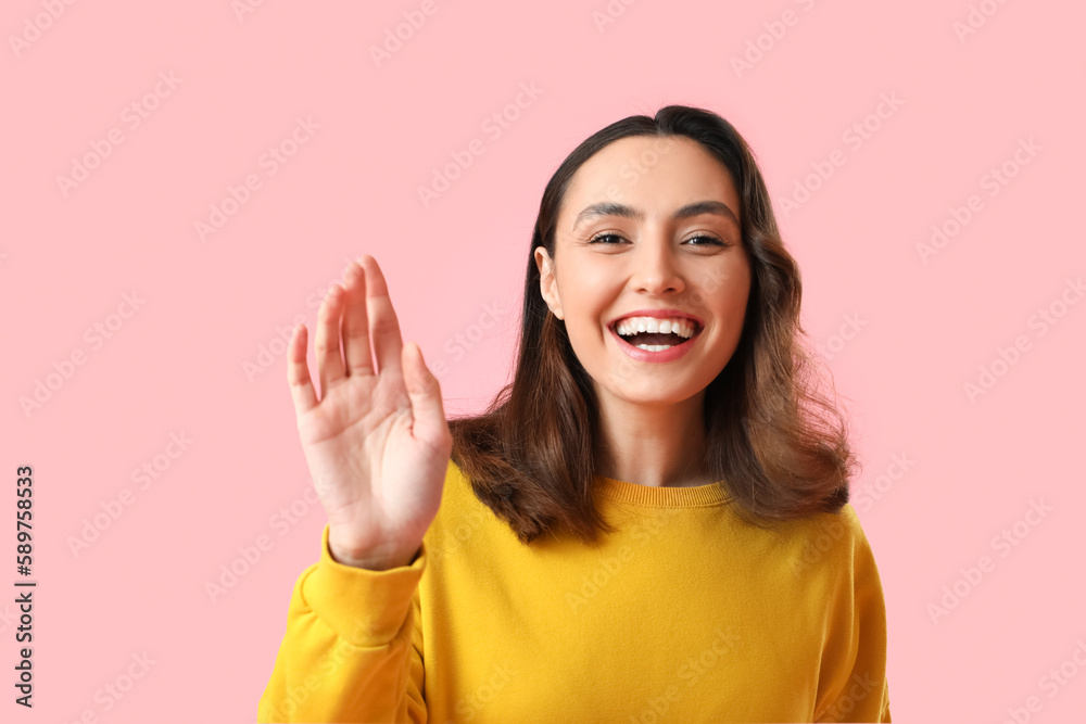 Happy young woman in yellow sweatshirt on pink background, closeup