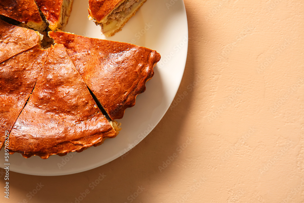 Plate with pieces of delicious meat pie on beige table, closeup