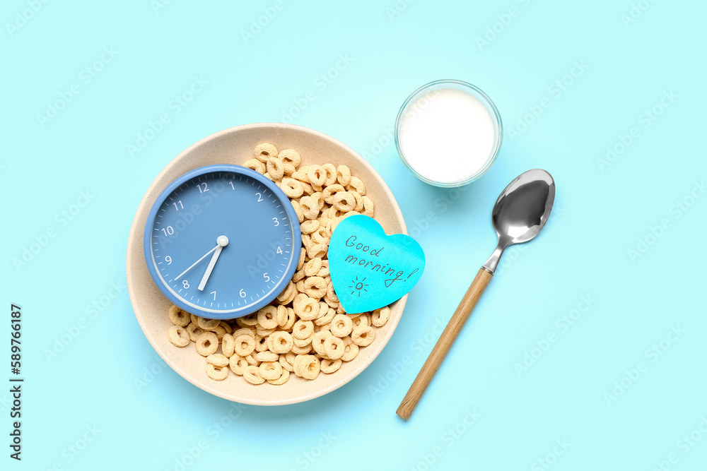 Bowl with tasty cereal rings, alarm clock and glass of milk on color background