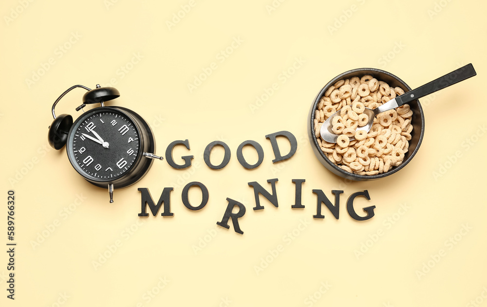 Composition with text GOOD MORNING, alarm clock and bowl of cereal rings on color background