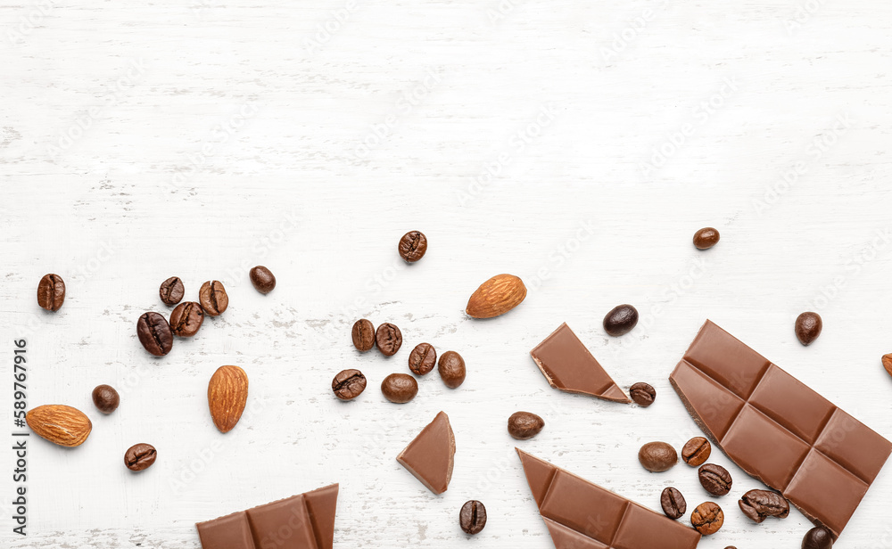 Composition with pieces of tasty chocolate, almonds and coffee beans on light wooden background