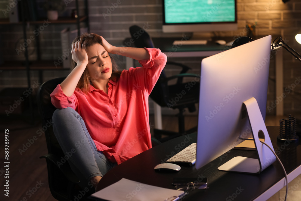 Stressed female programmer working in office at night