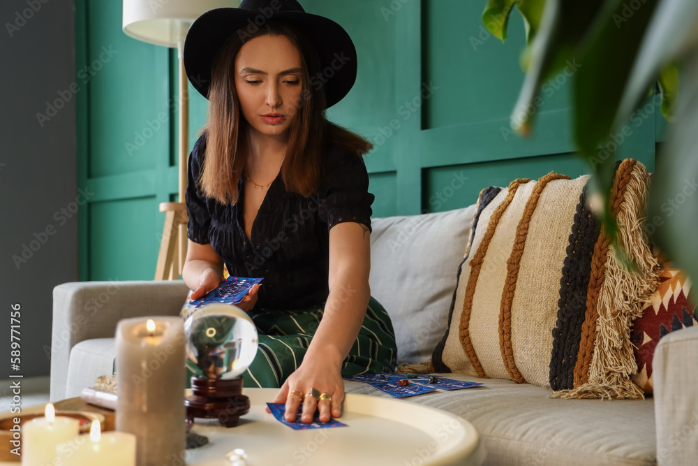 Young fortune teller with tarot cards at home