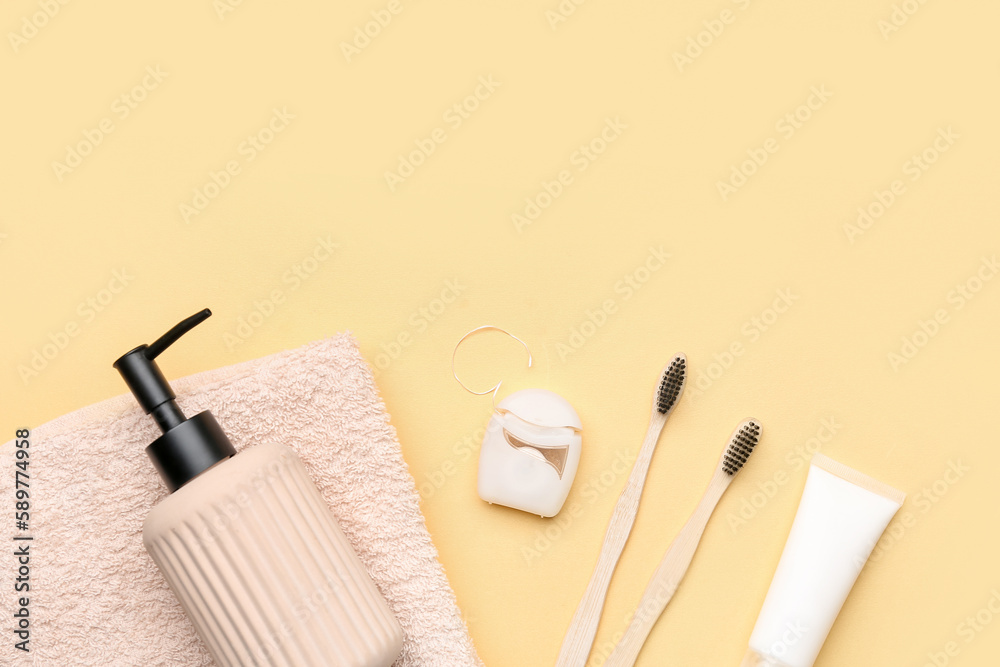 Dental floss and bath accessories on yellow background