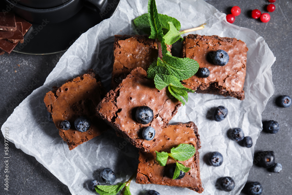 Pieces of tasty chocolate brownie on black background