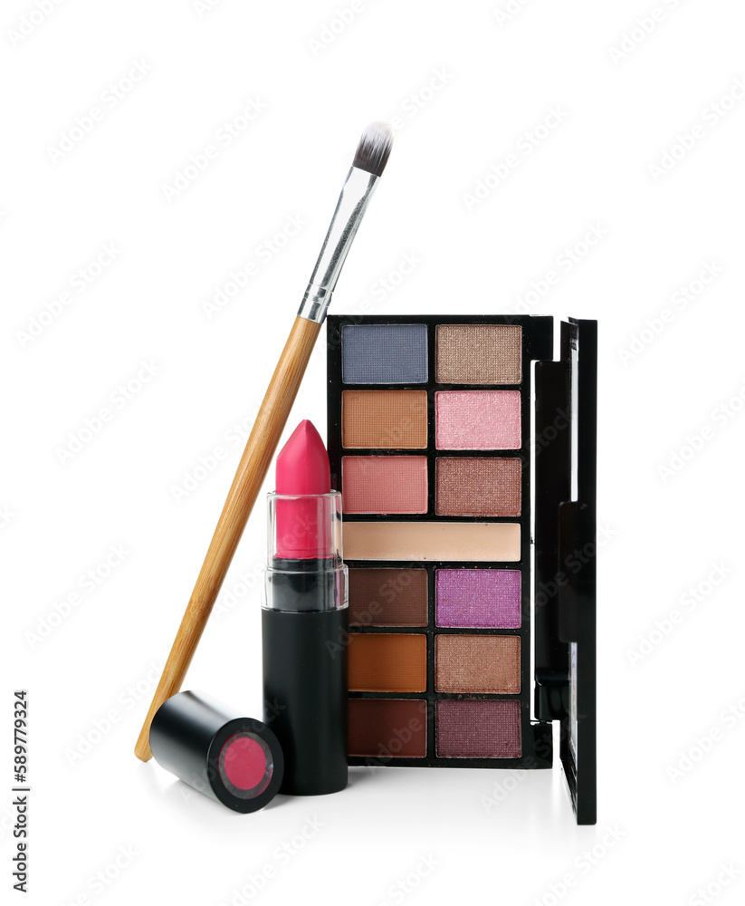 Makeup brush with lipsticks and eyeshadows on white background