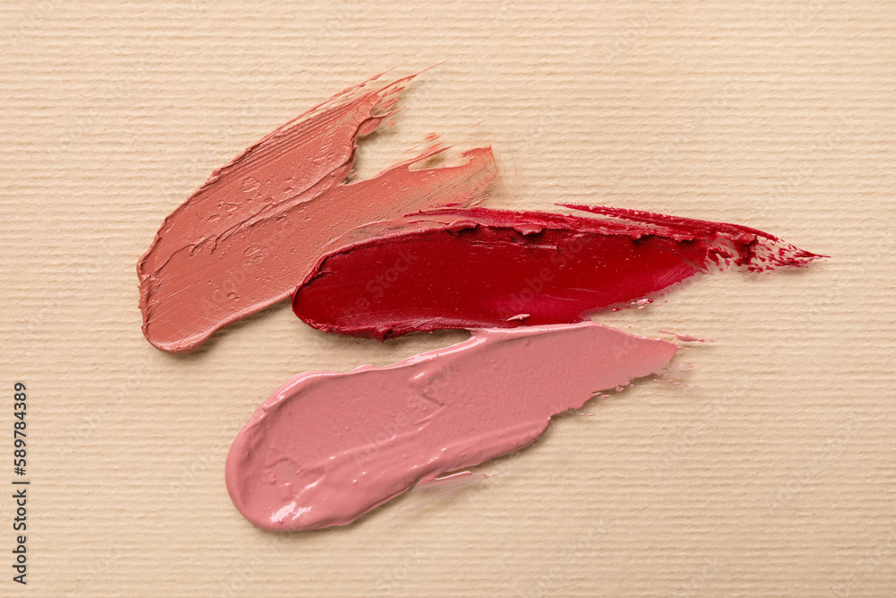 Different lipstick strokes on beige background