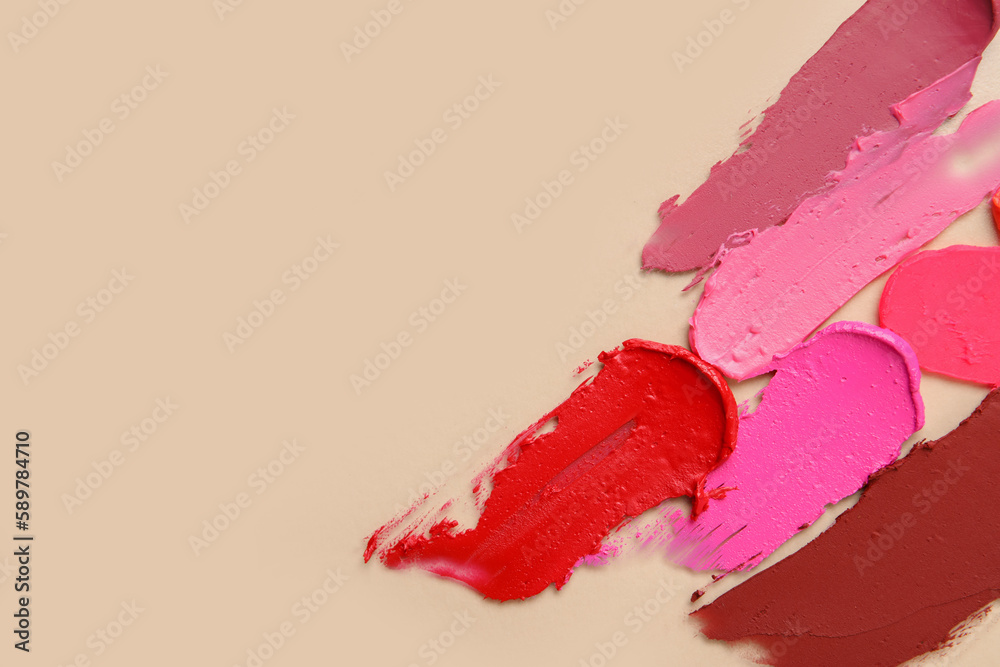 Different lipstick strokes on beige background