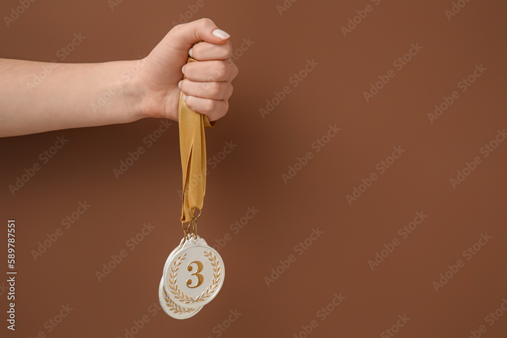 Woman with prize medals on brown background