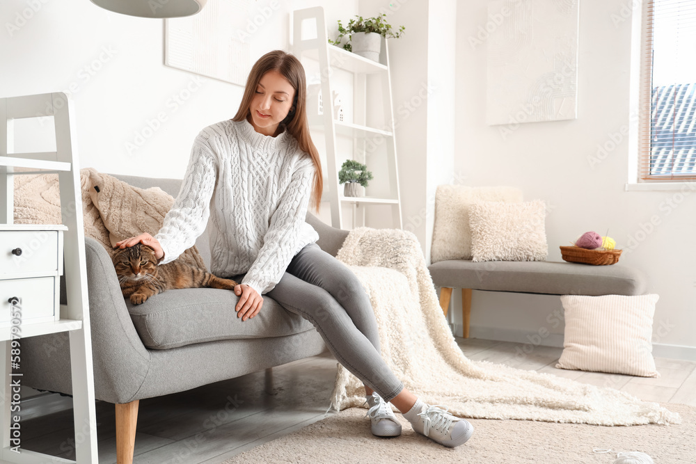 Young woman with striped Scottish fold cat at home