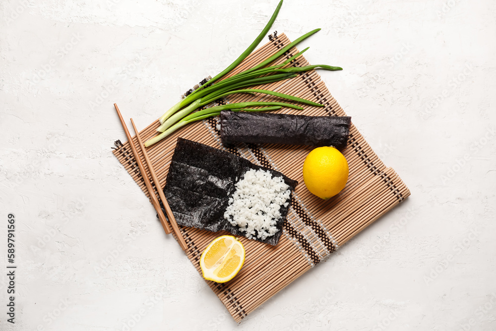 Nori with rice, sushi roll and lemon on light background