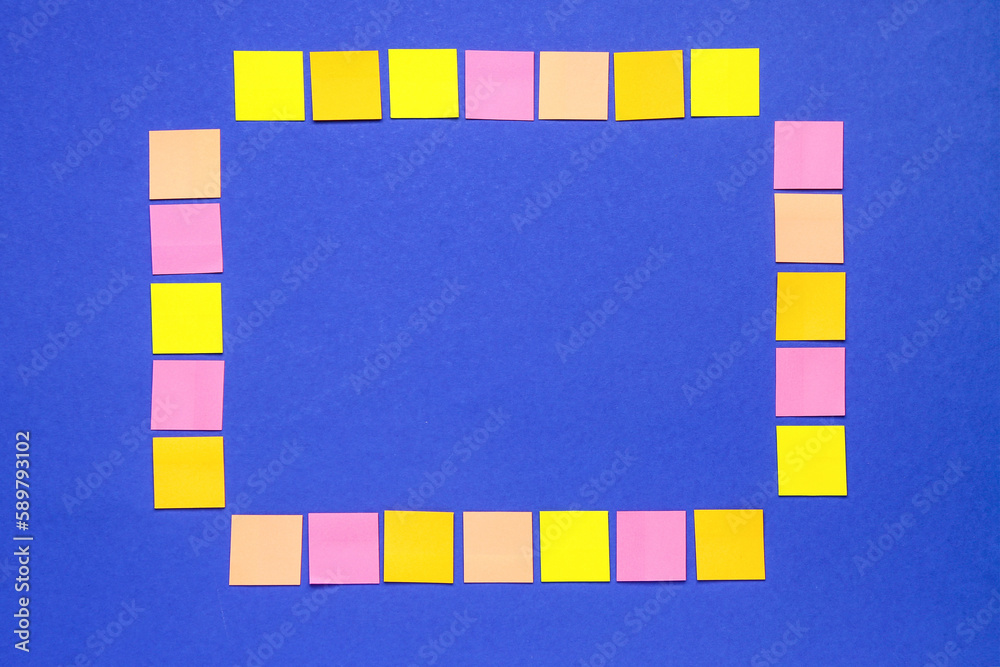 Frame made of colorful sticky notes on blue background