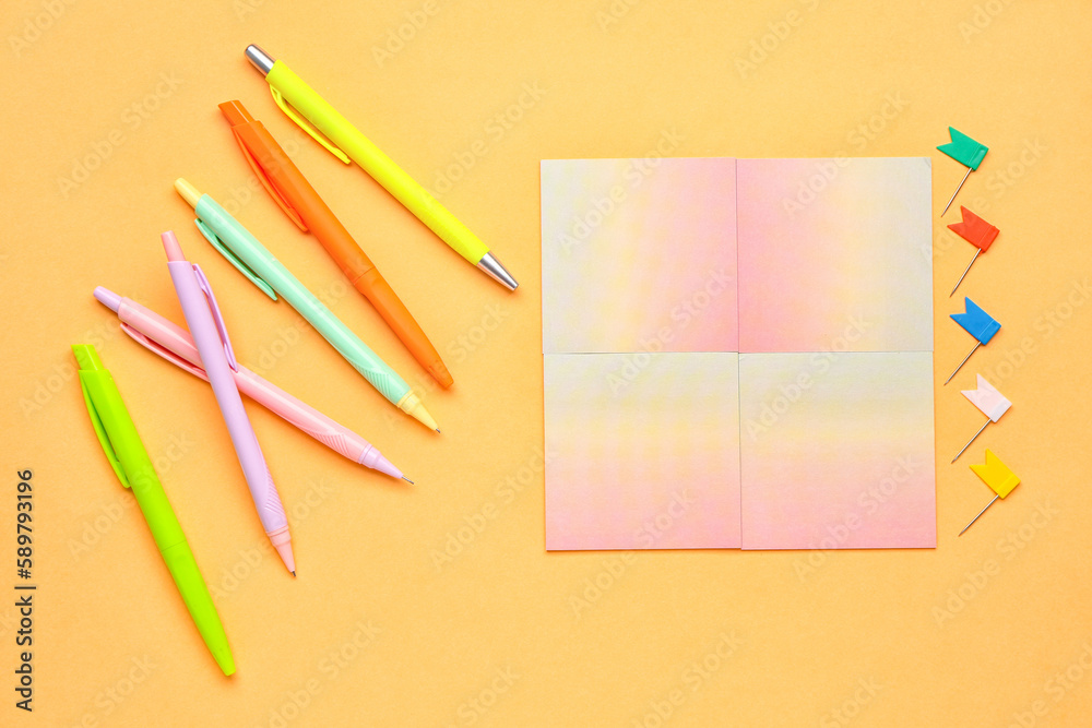 Sticky notes and colorful pens on yellow  background