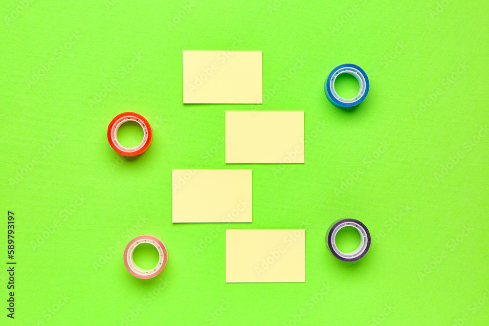 Sticky notes and scotch tapes on green background