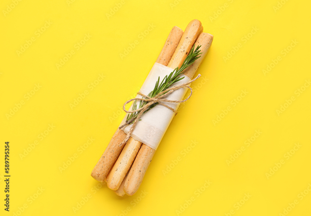 Bunch of tasty Italian Grissini on yellow background