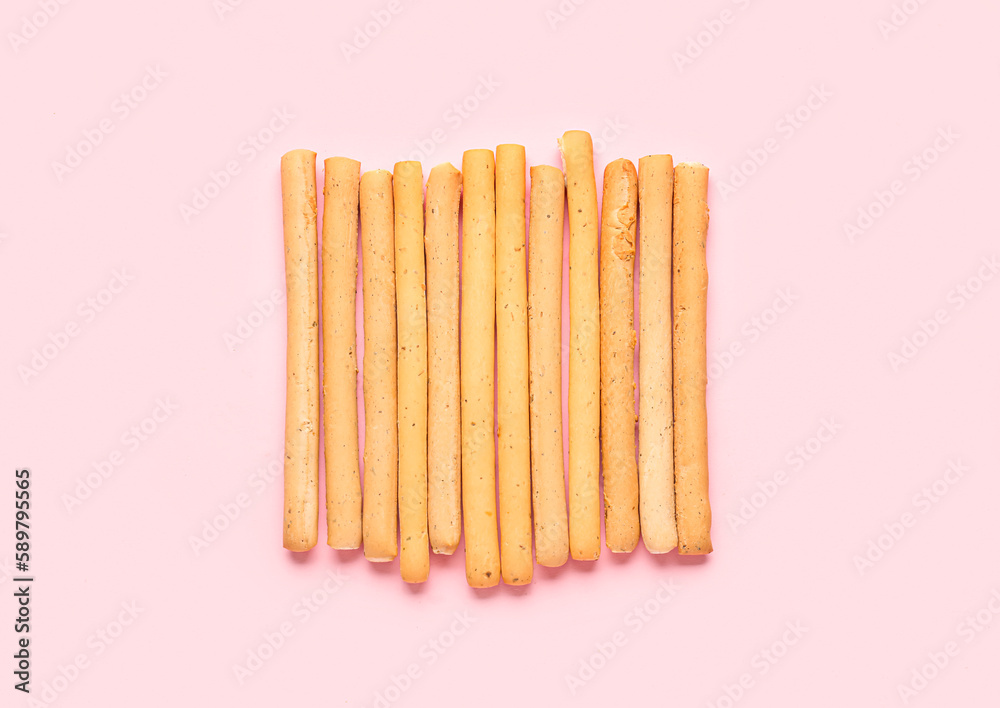 Tasty Italian Grissini on pink background