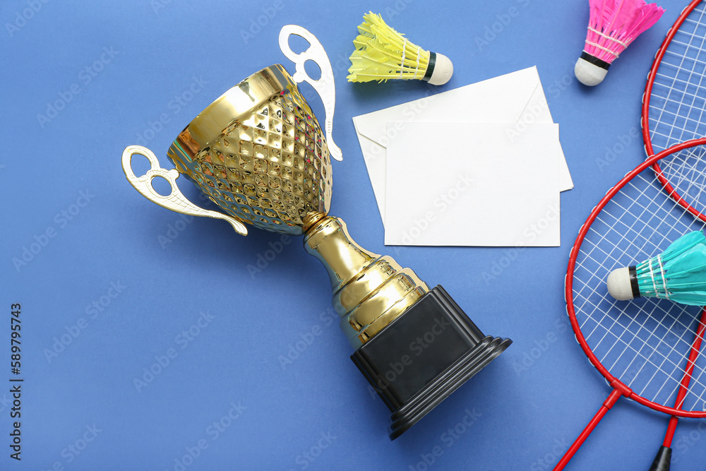 Blank card with gold cup and badminton equipment on blue background