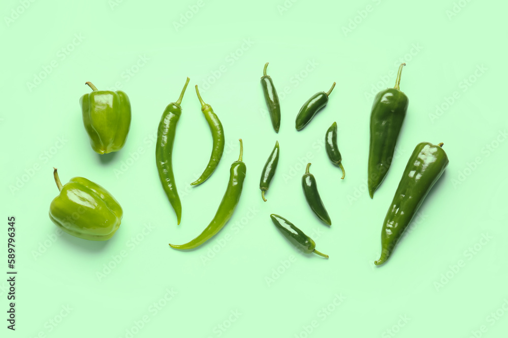 Composition with green peppers on color background