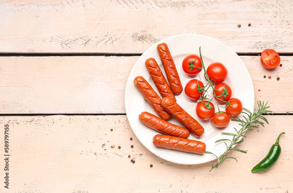 Plate with tasty grilled sausages and tomatoes on white wooden background