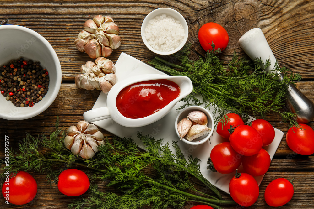 Gravy boat with tasty ketchup and fresh vegetables on wooden background