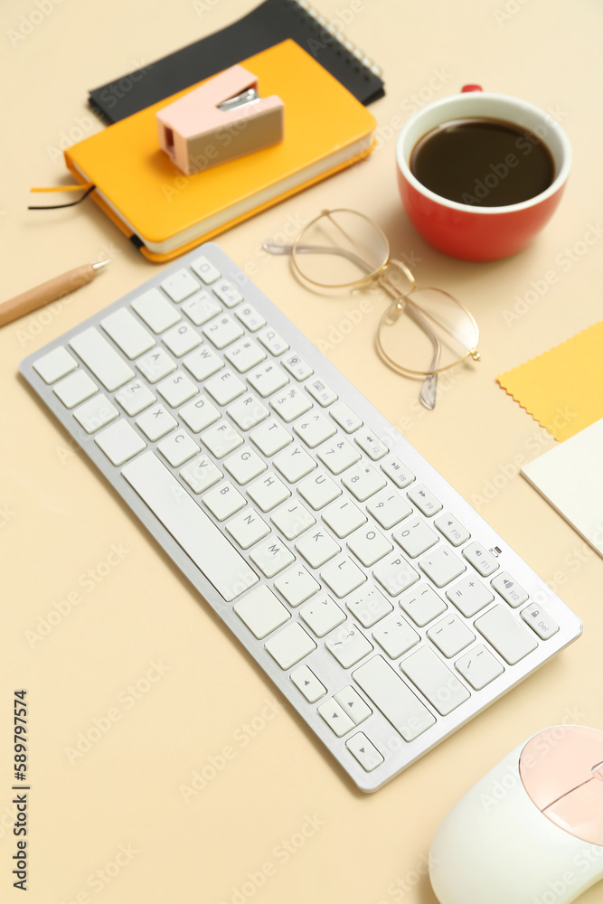 Composition with keyboard, coffee, calculator and notepad on beige background