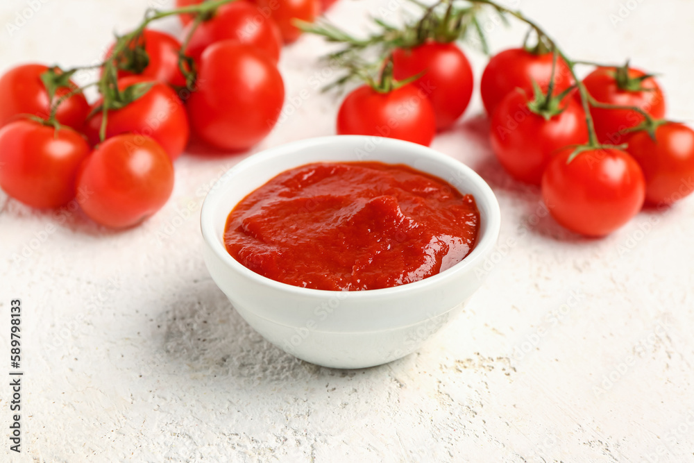 Bowl with tasty tomato paste on light background, closeup