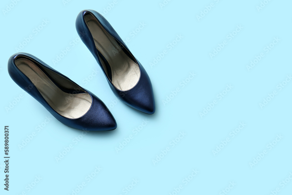 Pair of stylish high heeled shoes on light blue background