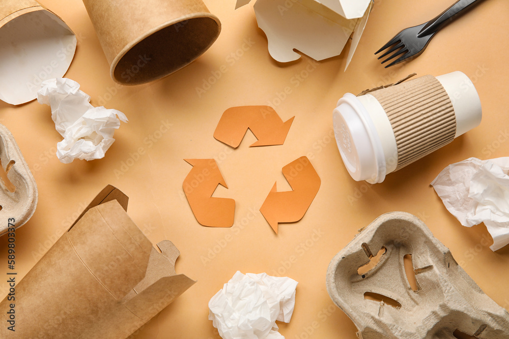 Recycling sign with paper garbage on beige background