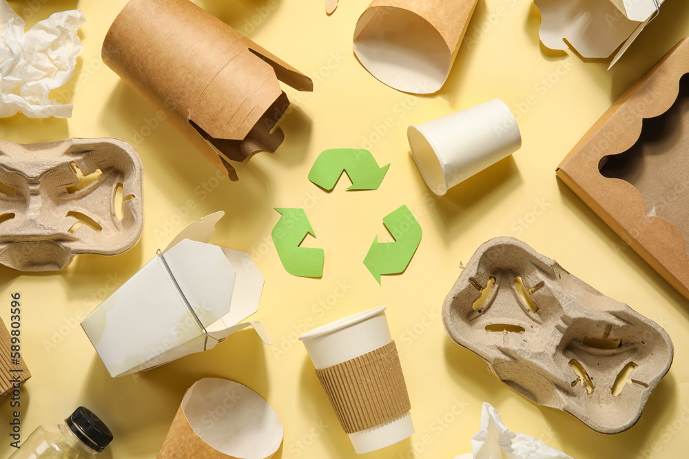 Recycling sign with garbage on yellow background