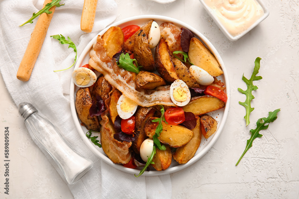 Plate of tasty potato salad with eggs, tomatoes and bacon on table, top view