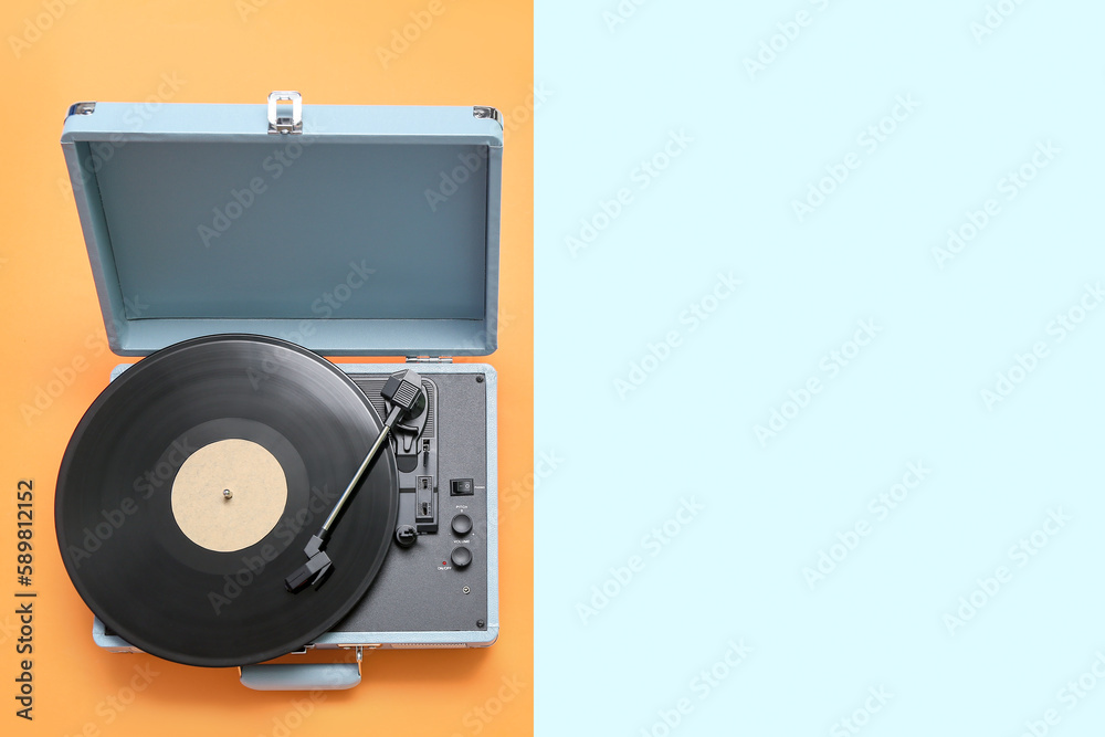 Record player with vinyl disk on color background