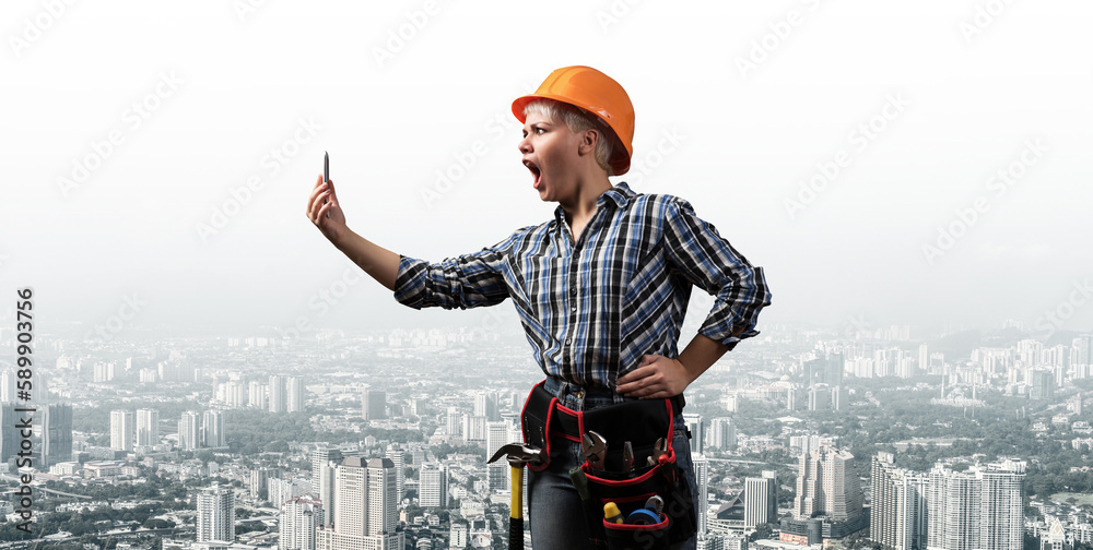 Expressive blonde woman in workwear and hardhat