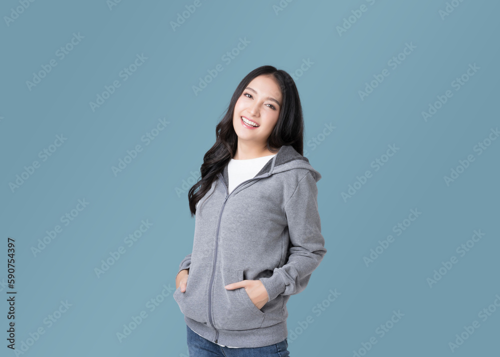 Portrait beautiful Asian woman in hoodie sweatshirt and blue jeans isolated over cyan background